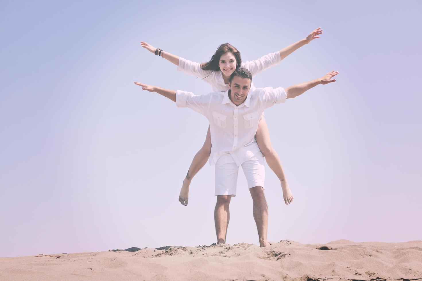 happy young couple have fun on beach photo