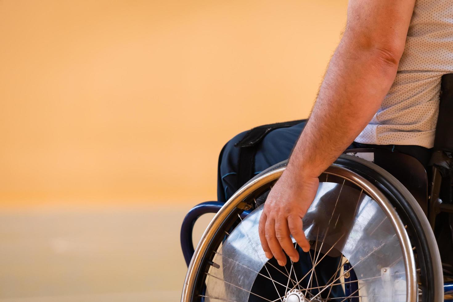 Close up photo of wheelchairs and handicapped war veterans playing basketball on the court