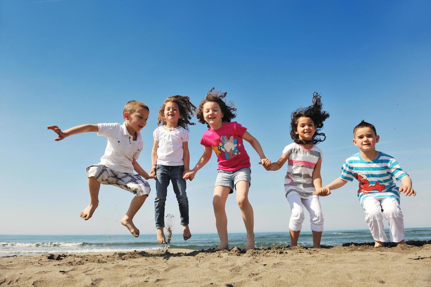 happy child group playing  on beach photo