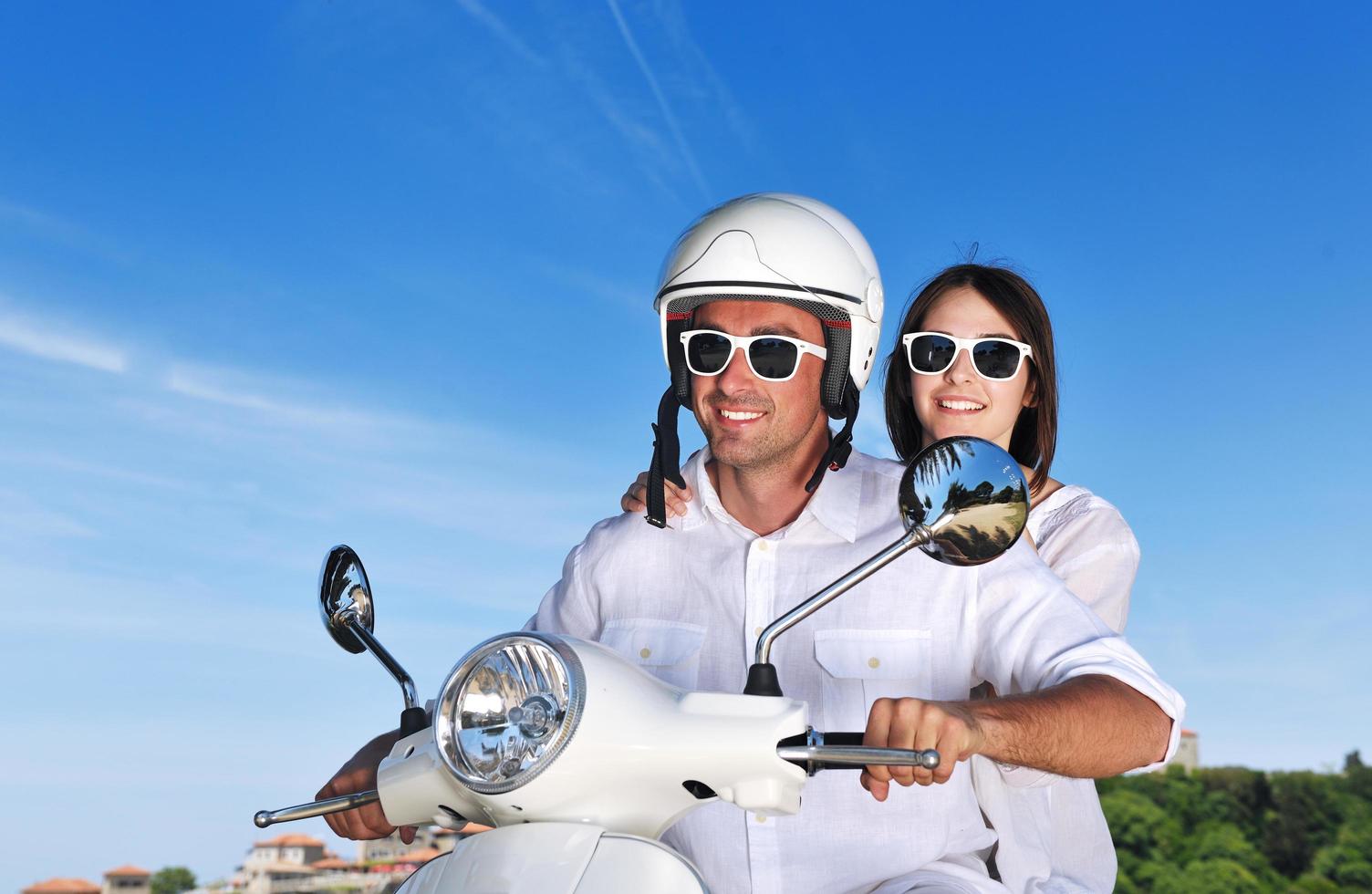 Portrait of happy young love couple on scooter enjoying summer time photo