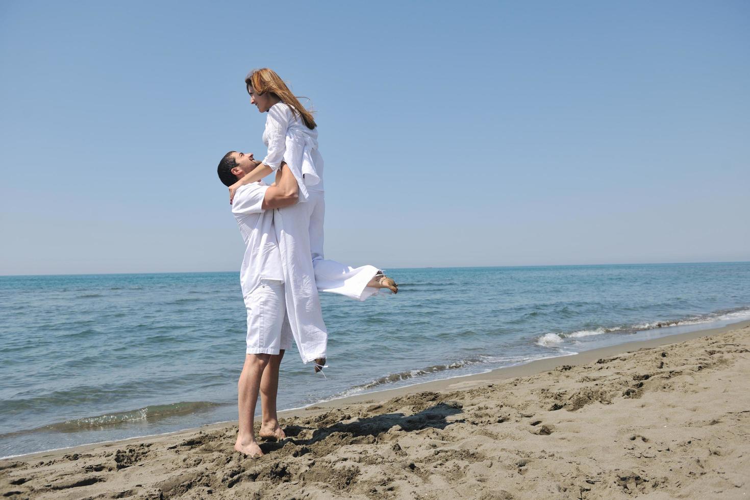 happy young couple have fun on beach photo
