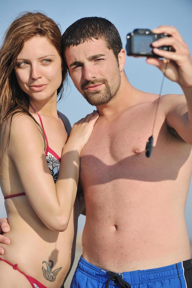 happy young couple in love taking photos on beach