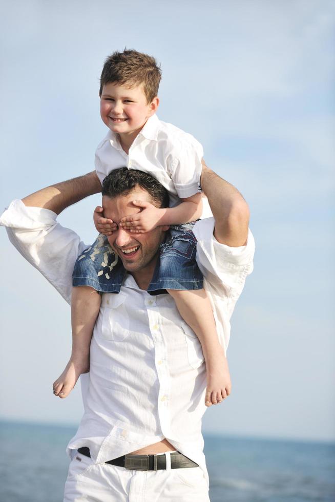 feliz padre e hijo se divierten y disfrutan del tiempo en la playa foto