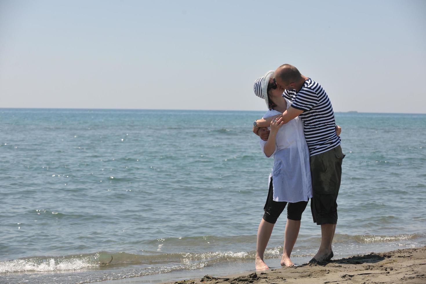 feliz pareja joven divertirse en la playa foto