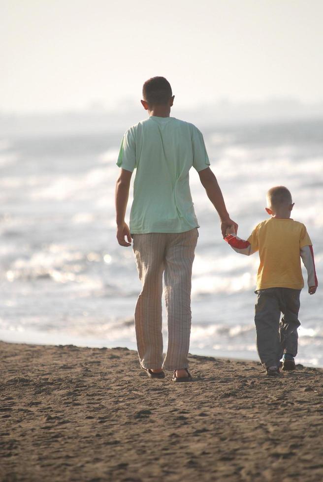 padre e hijo caminando en la playa foto