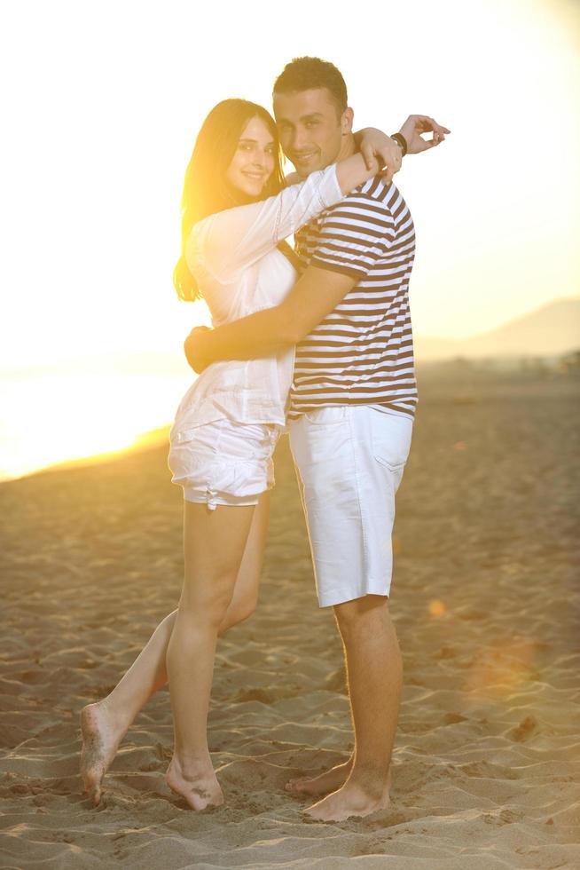 feliz pareja joven tiene tiempo romántico en la playa foto