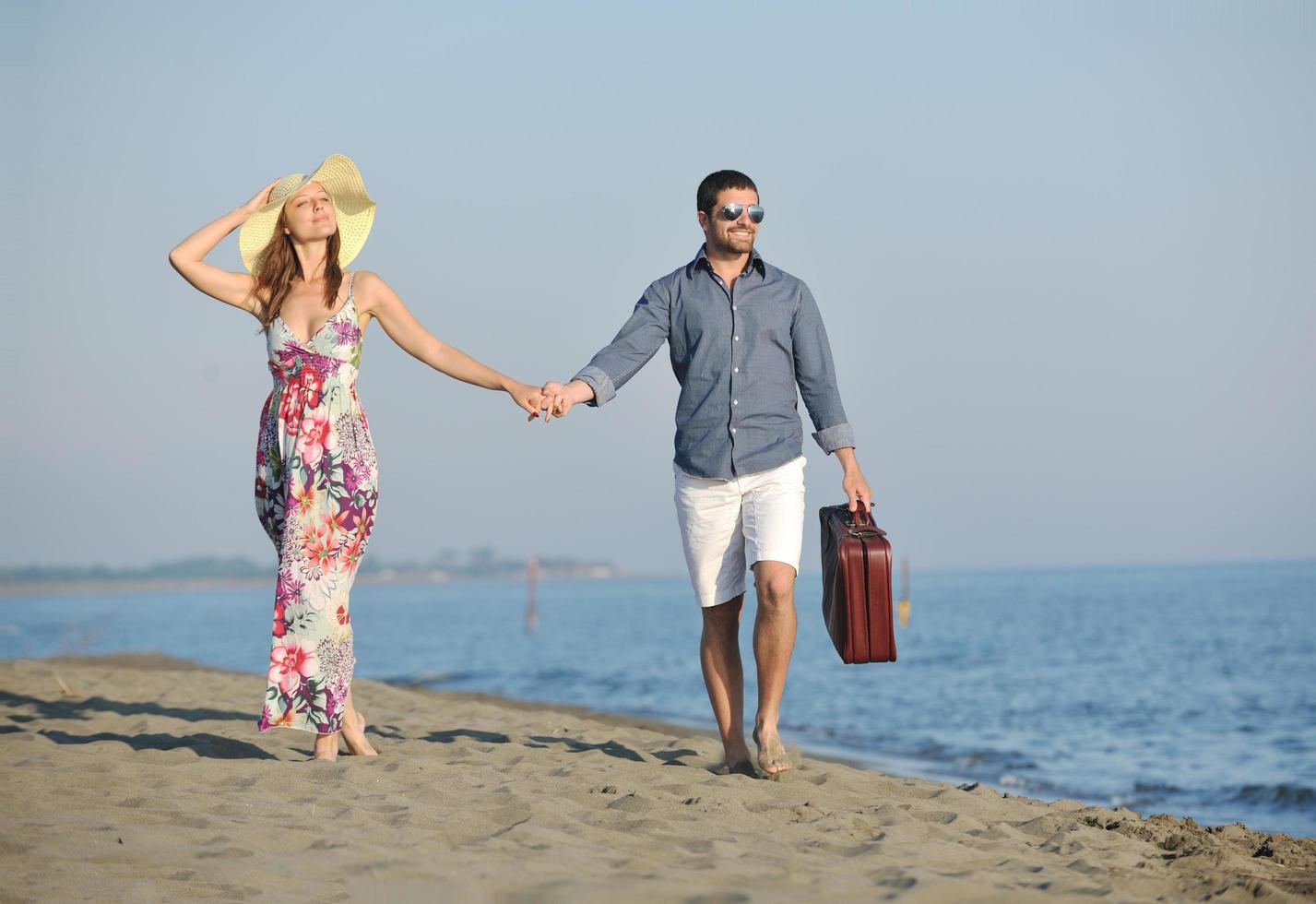 couple on beach with travel bag photo