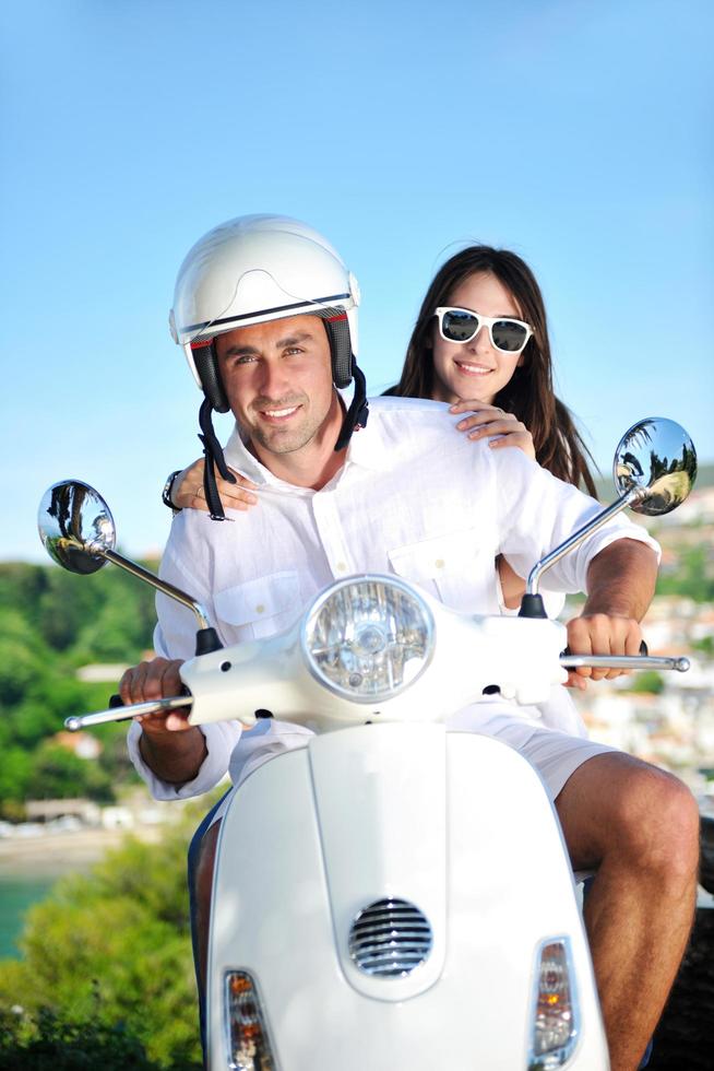 Portrait of happy young love couple on scooter enjoying summer time photo