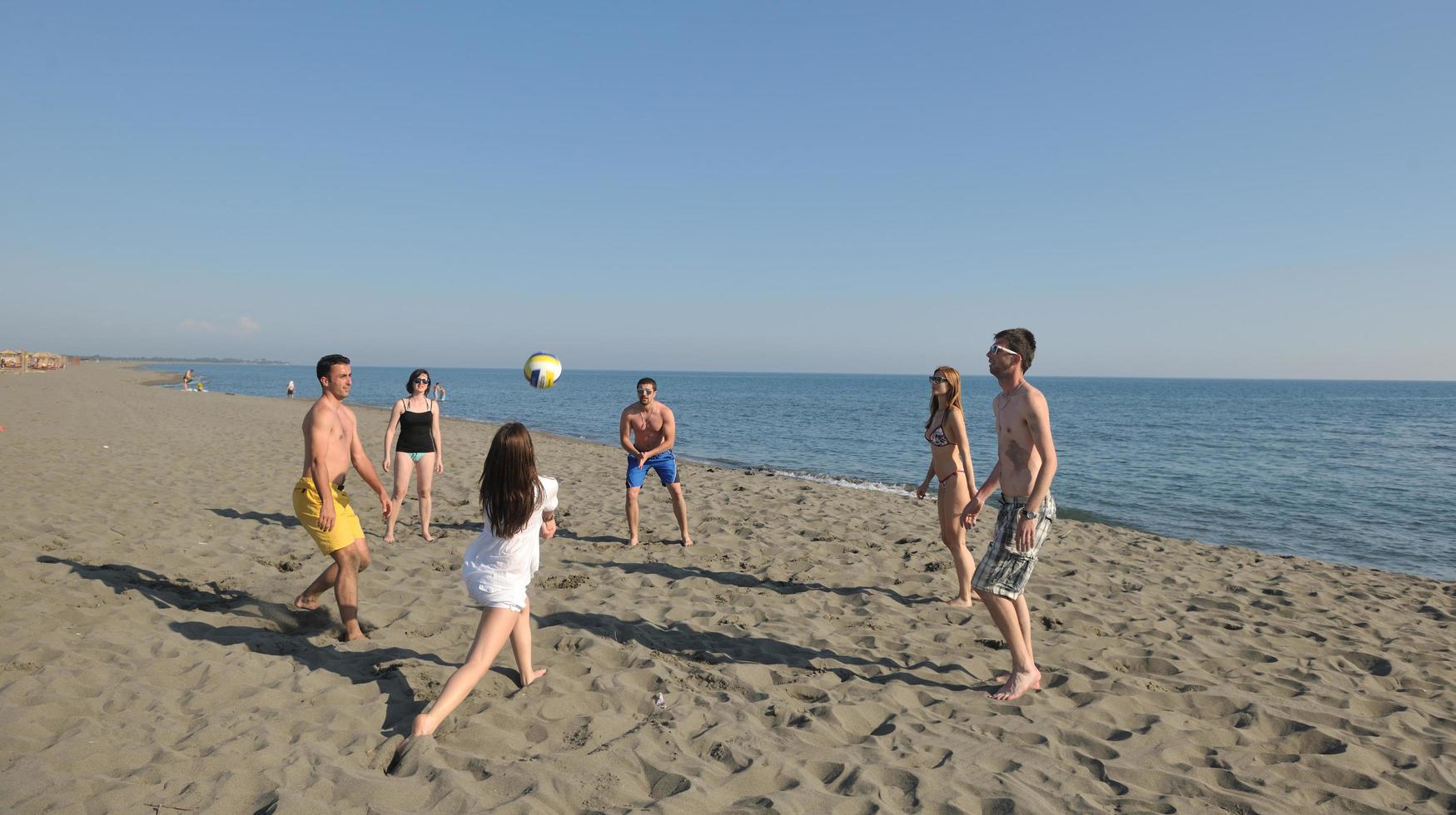 young people group have fun and play beach volleyball photo