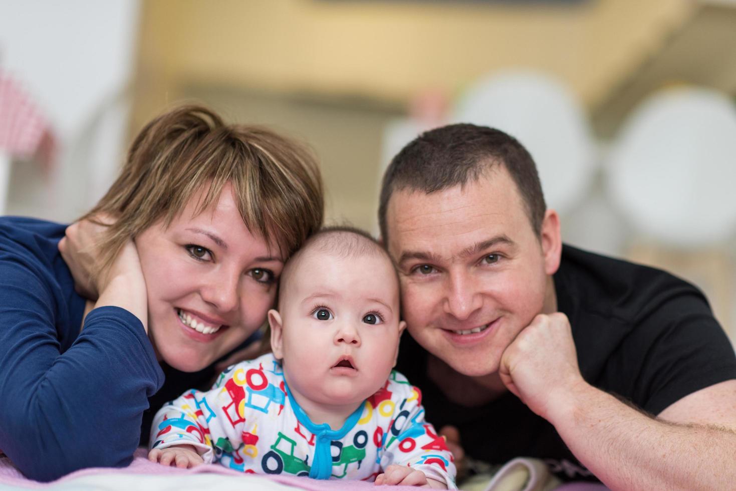 Portrait of young happy couple with their adorable baby boy photo