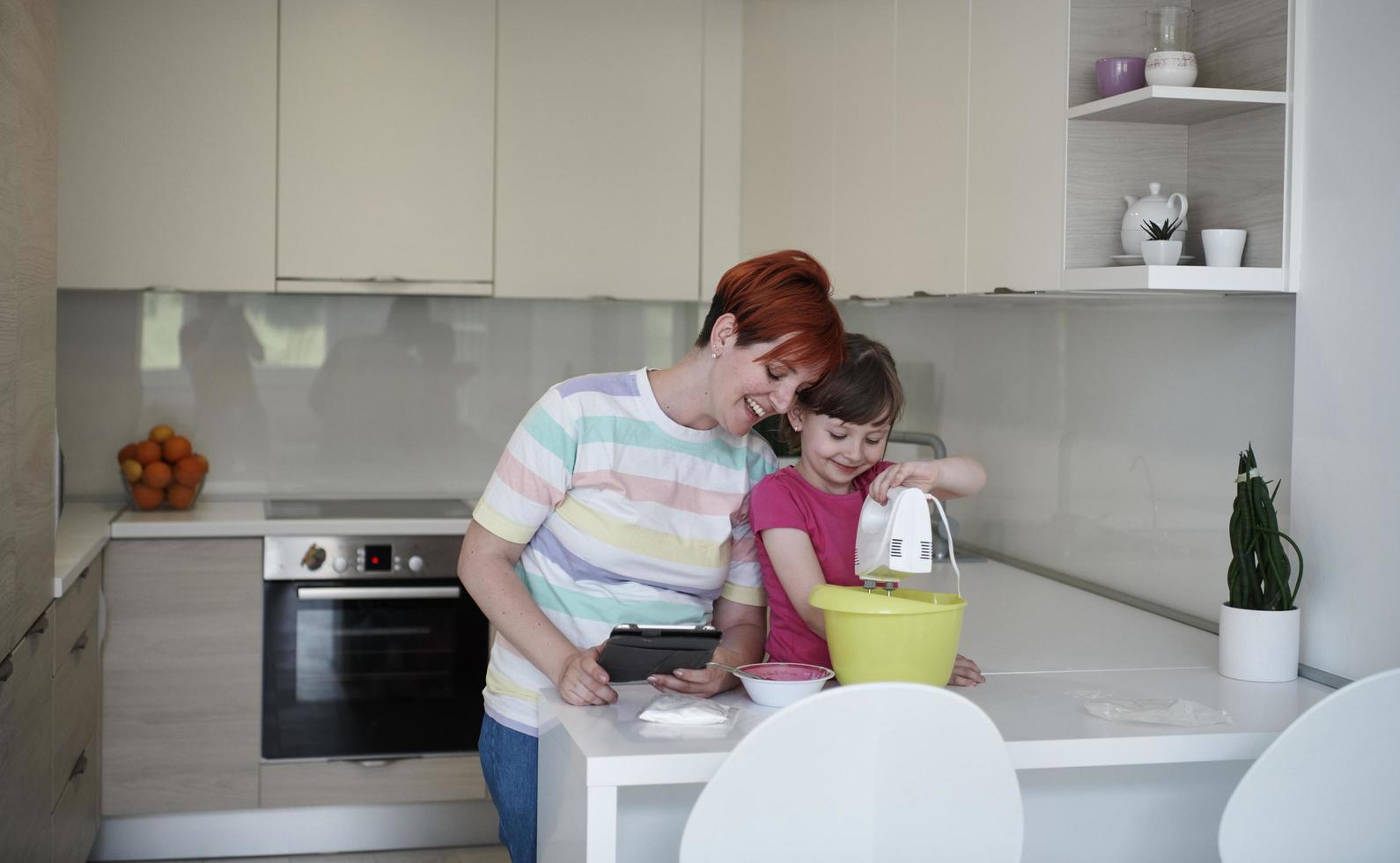 Mother and daughter playing and preparing dough in the kitchen. photo