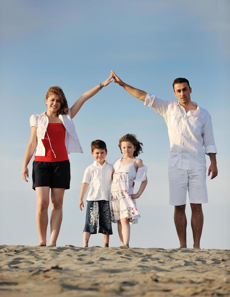 family on beach showing home sign photo