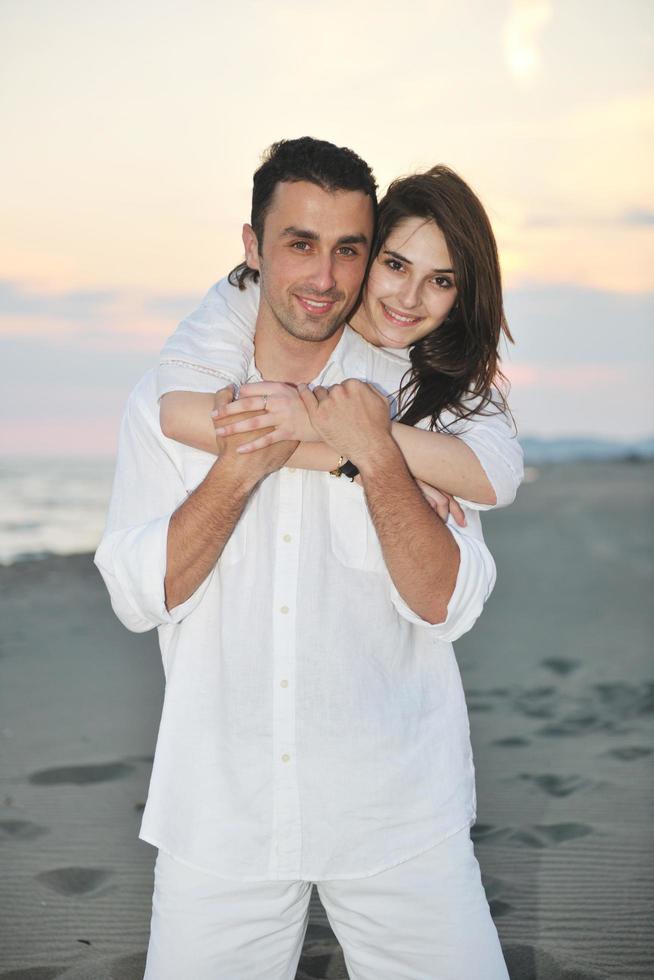 feliz pareja joven divertirse en la playa foto