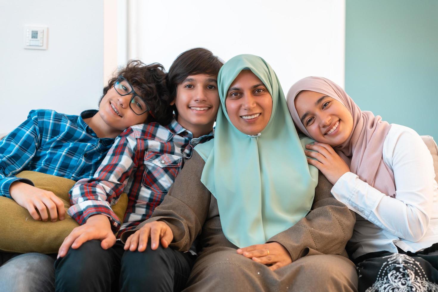 Middle eastern family portrait single mother with teenage kids at home in living room. Selective focus photo