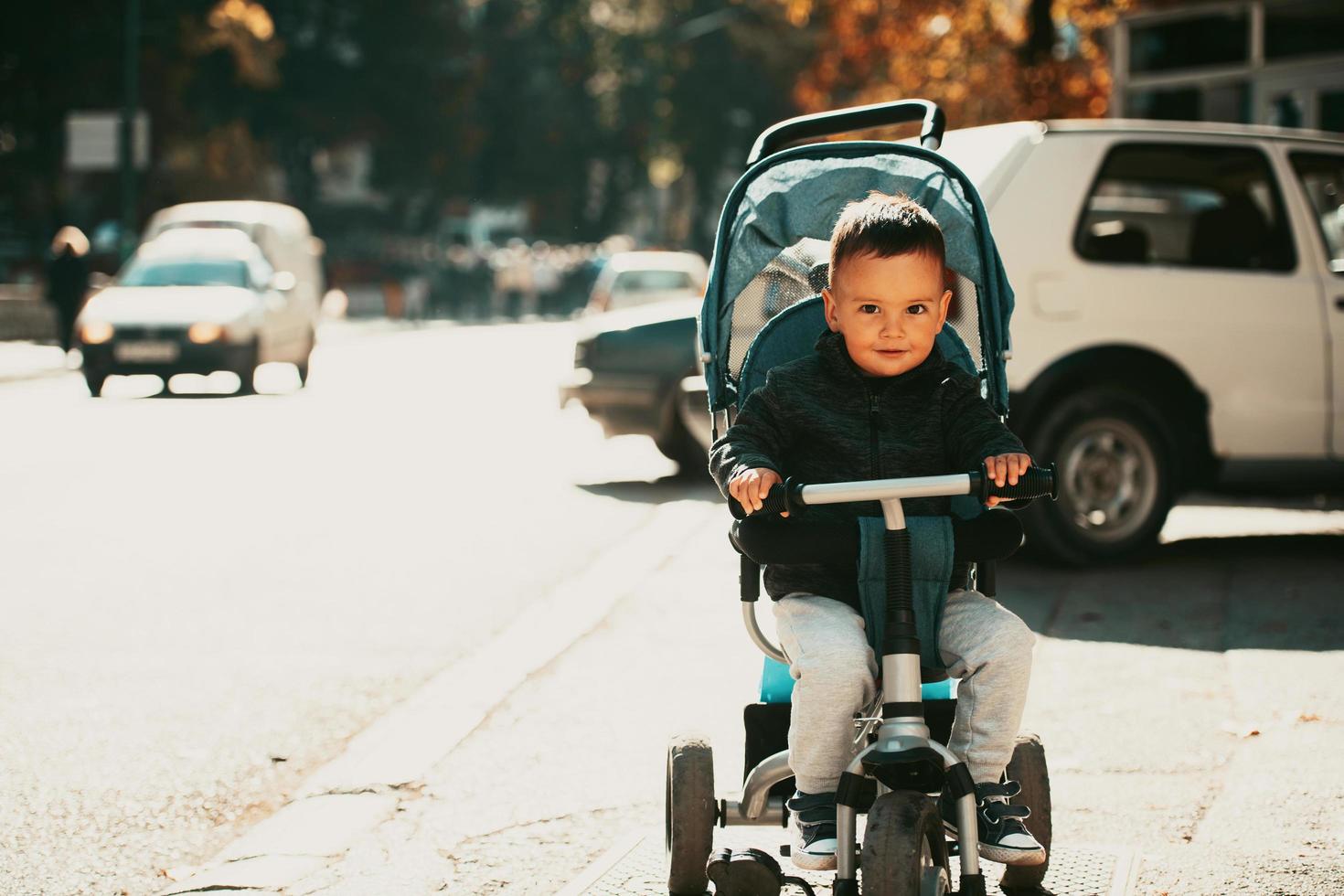 Sweet baby boy in a stroller bicycle outdoors. Little child in a pram. Infant kid in a pushchair. Spring walks with kids. photo