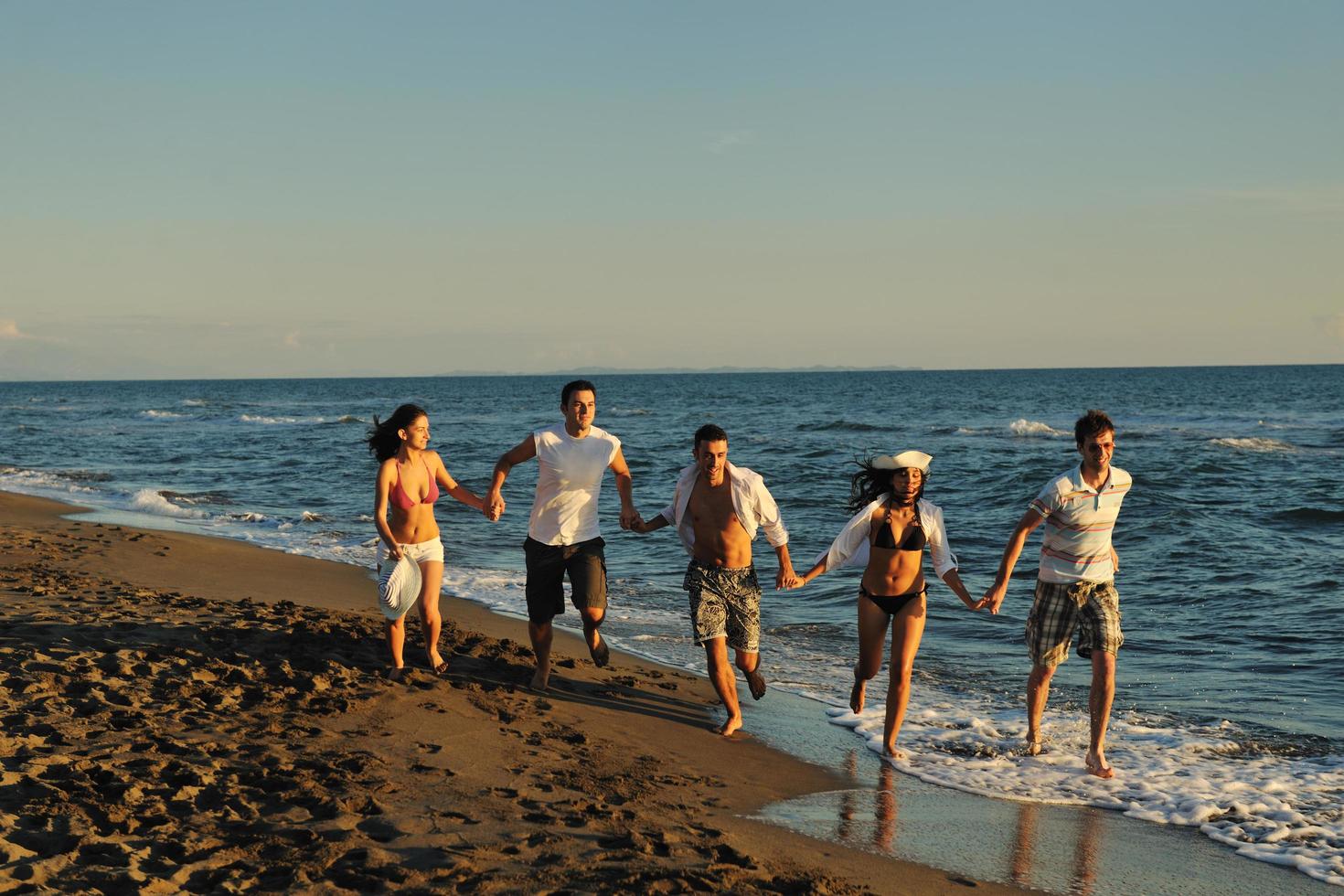 grupo de personas corriendo en la playa foto