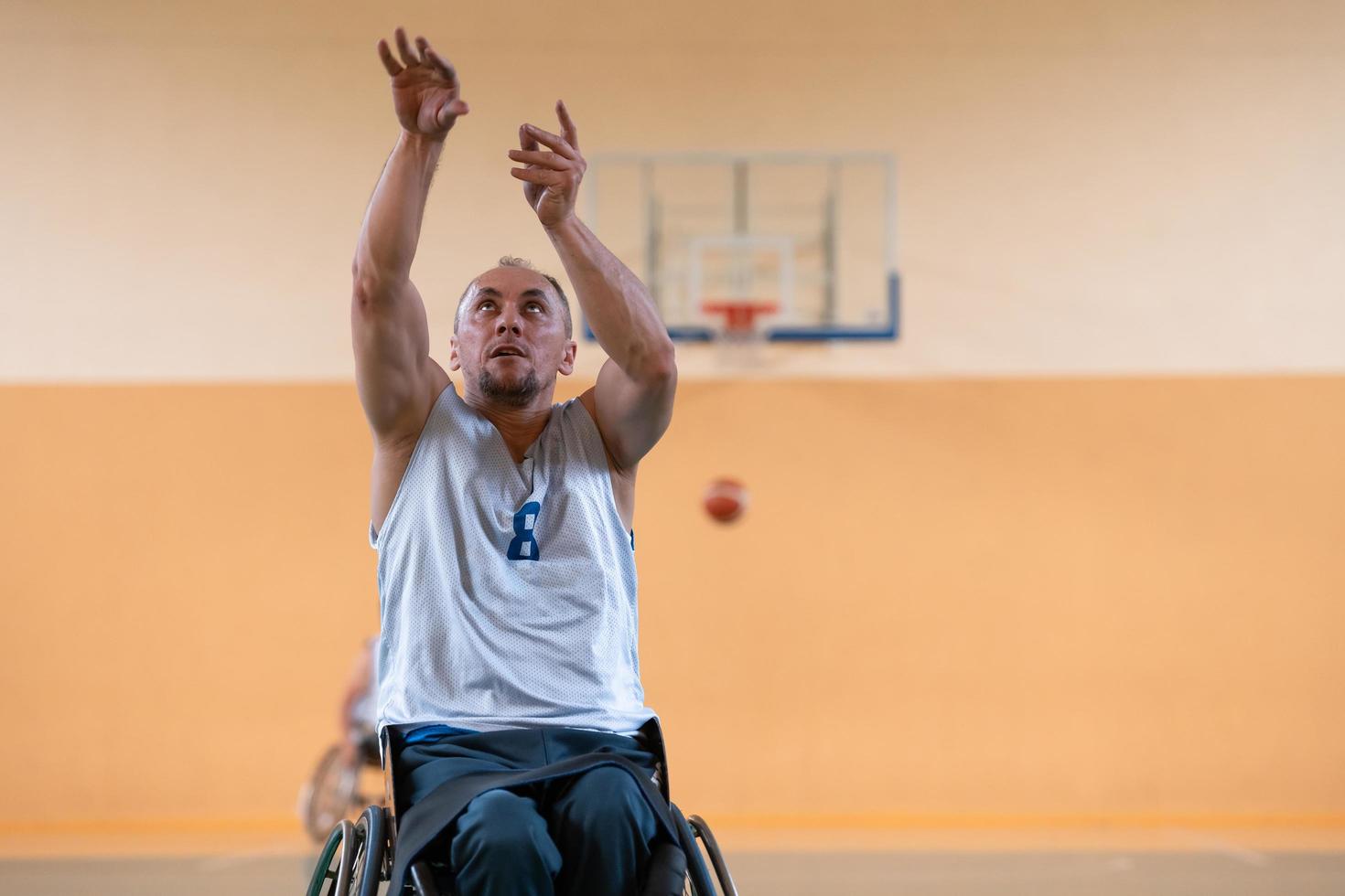 a photo of a war veteran playing basketball with a team in a modern sports arena. The concept of sport for people with disabilities