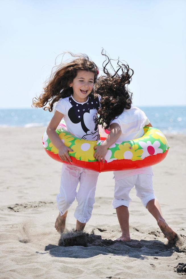 Grupo de niños felices jugando en la playa foto