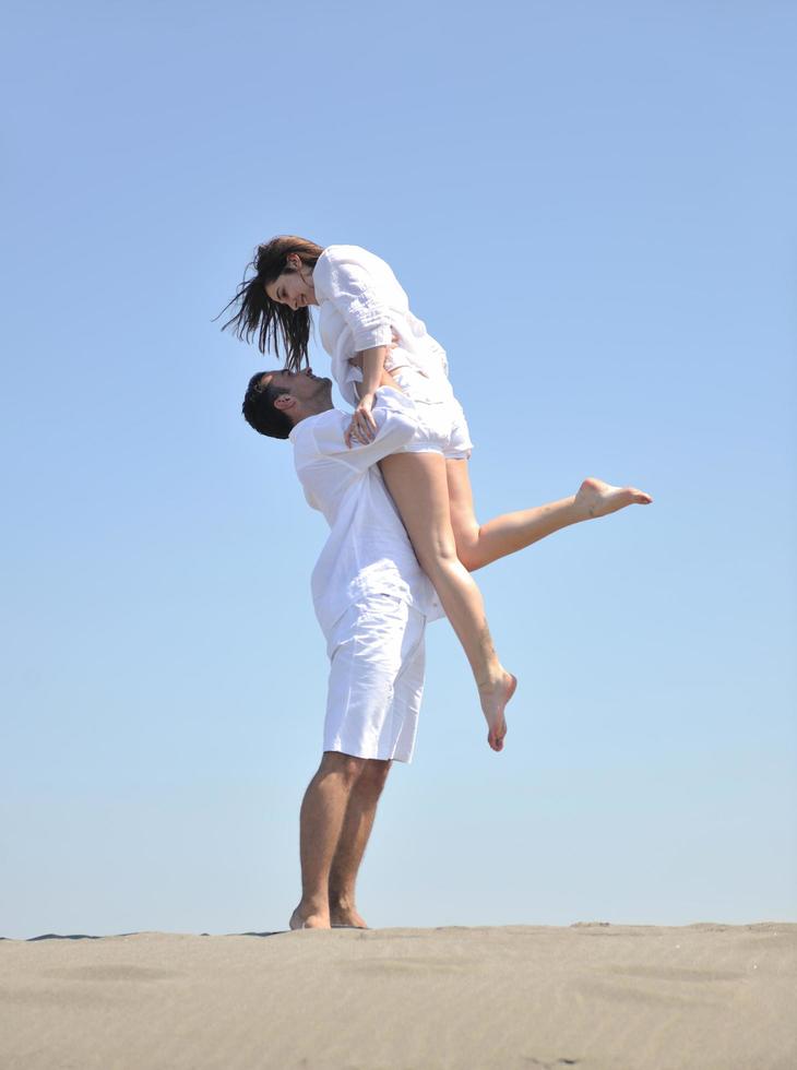 happy young couple have fun on beach photo