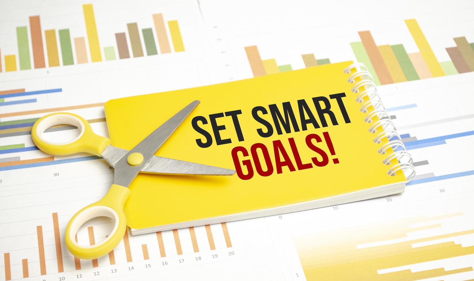 A notepad with the text set SMART goals pen, reports, photo