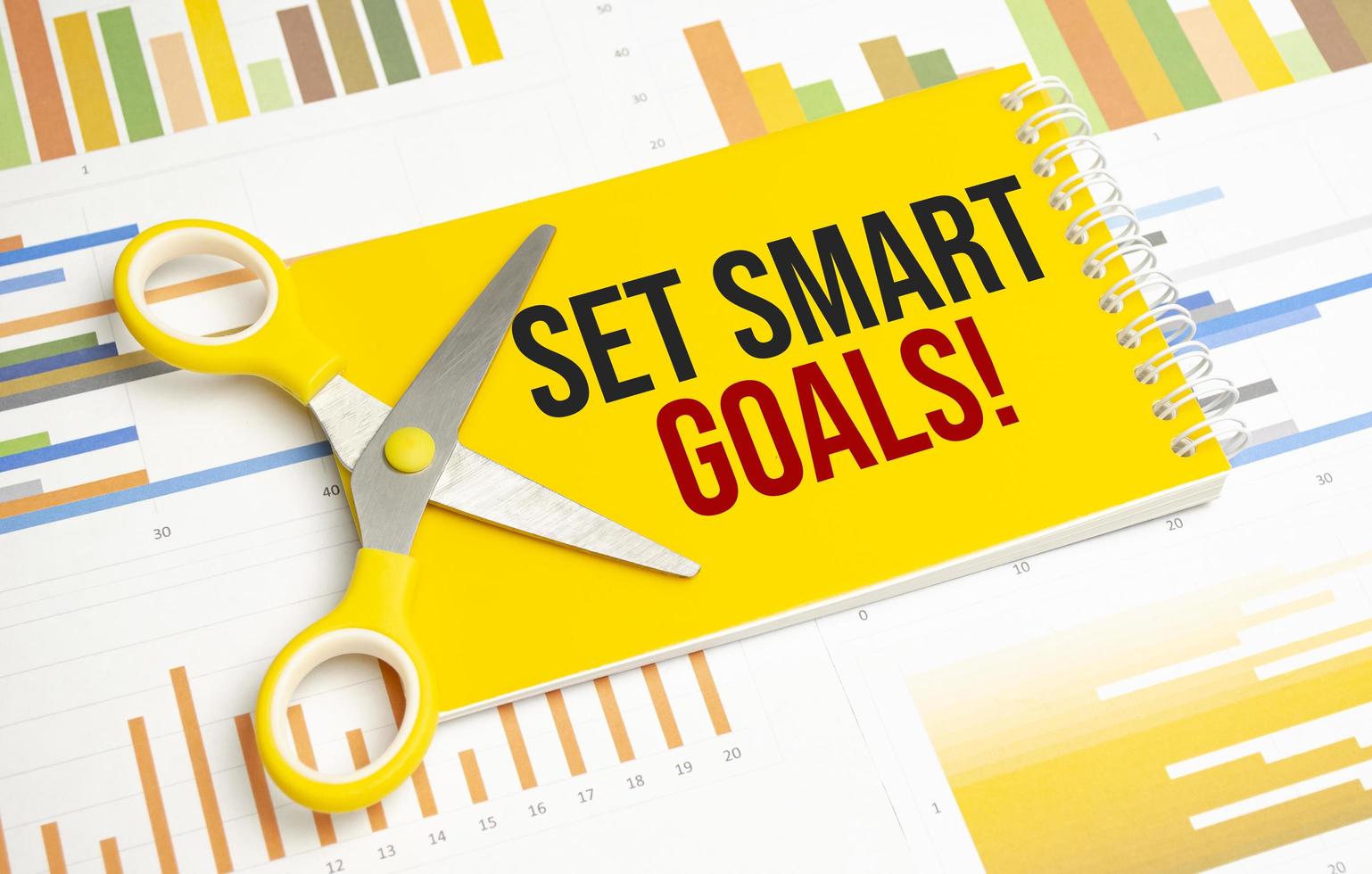 A notepad with the text set SMART goals pen, reports, photo