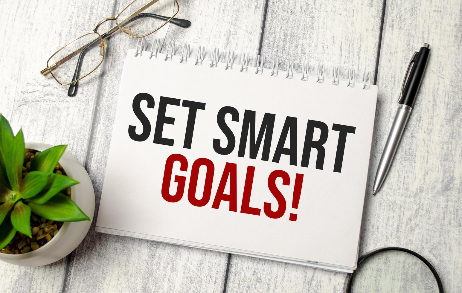 concept word set SMART goals on notepad and office supplies photo