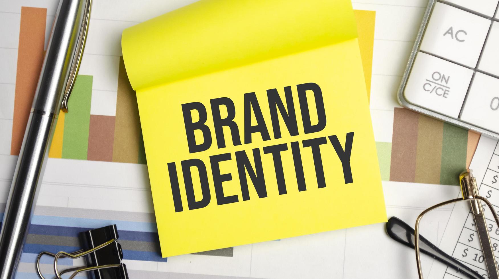 brand identity text on the yellow paper with pen and glasses photo