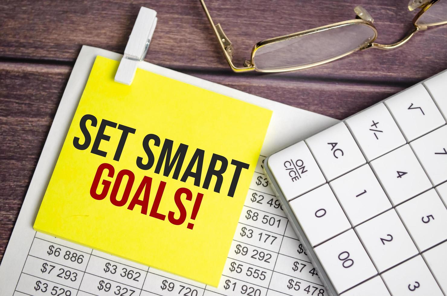 A notepad with the text set SMART goals pen, reports, photo