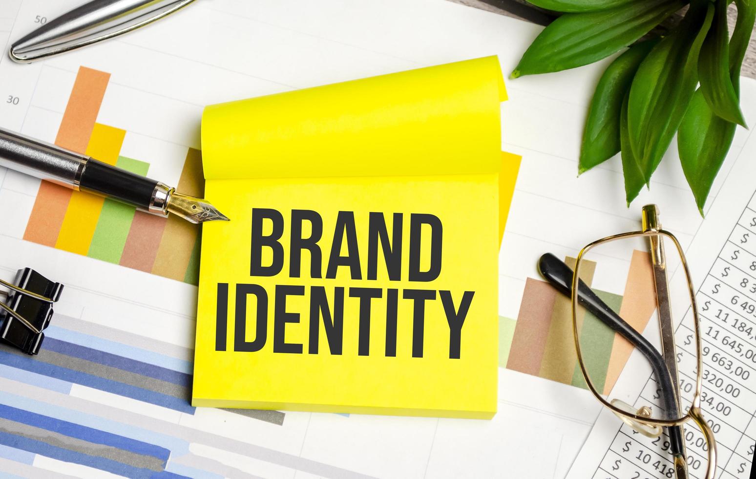 brand identity text on the yellow paper with pen and glasses photo