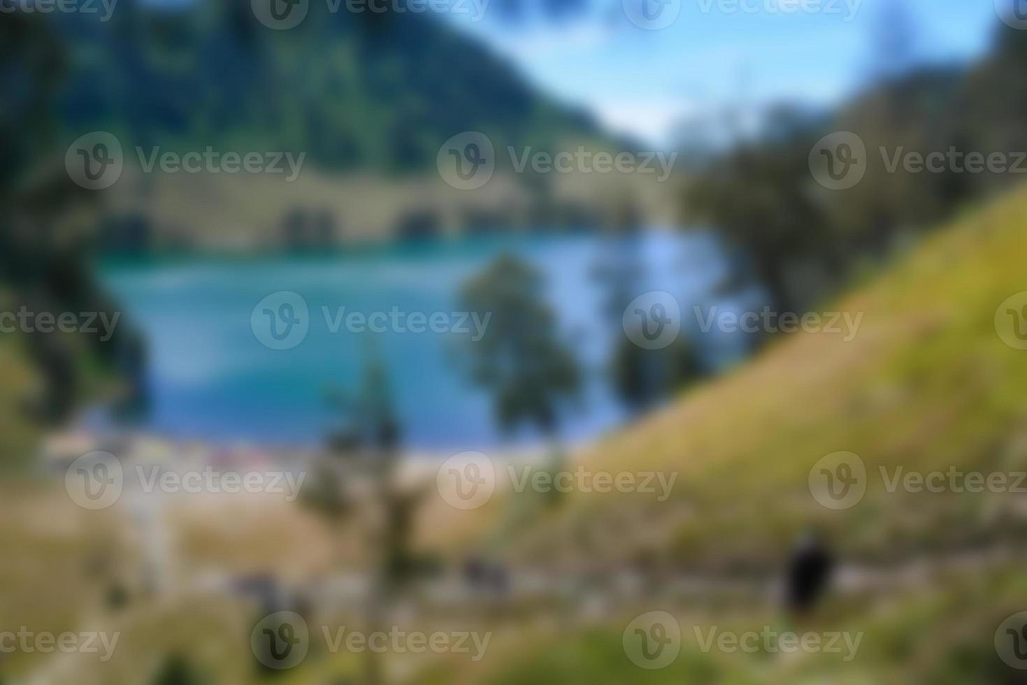 Blurred view of lake ranu kumbolo, semeru mountain. bokeh background in summer, green nature concept photo