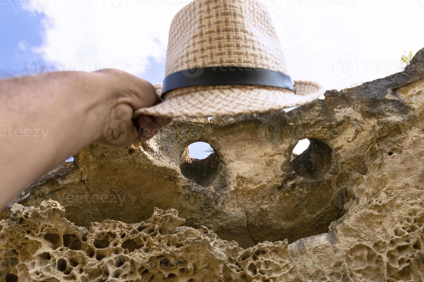 The top of the cliff in the form of a smiling face with eyes and a mouth and a hat. Texture, weathered limestone background. The bottom of the ancient sea. Abstract background. photo