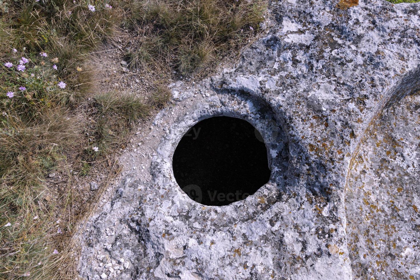 la antigua ciudad cueva de bakla, vista exterior. hoyos de grano redondos para el almacenamiento de granos. foto