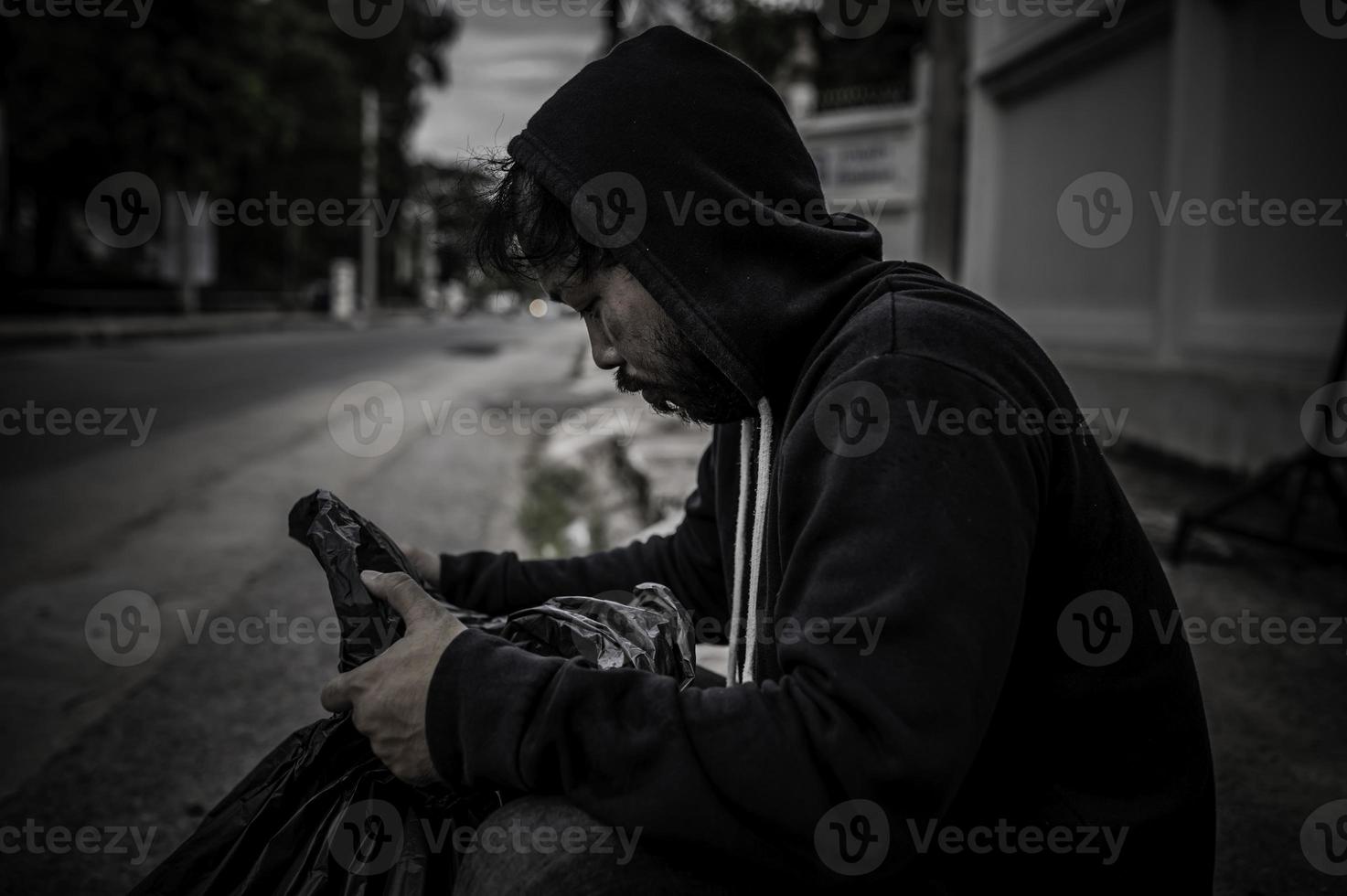 un hombre asiático no tiene hogar en la calle lateral, un extraño tiene que vivir solo en la calle porque no tiene familia. foto