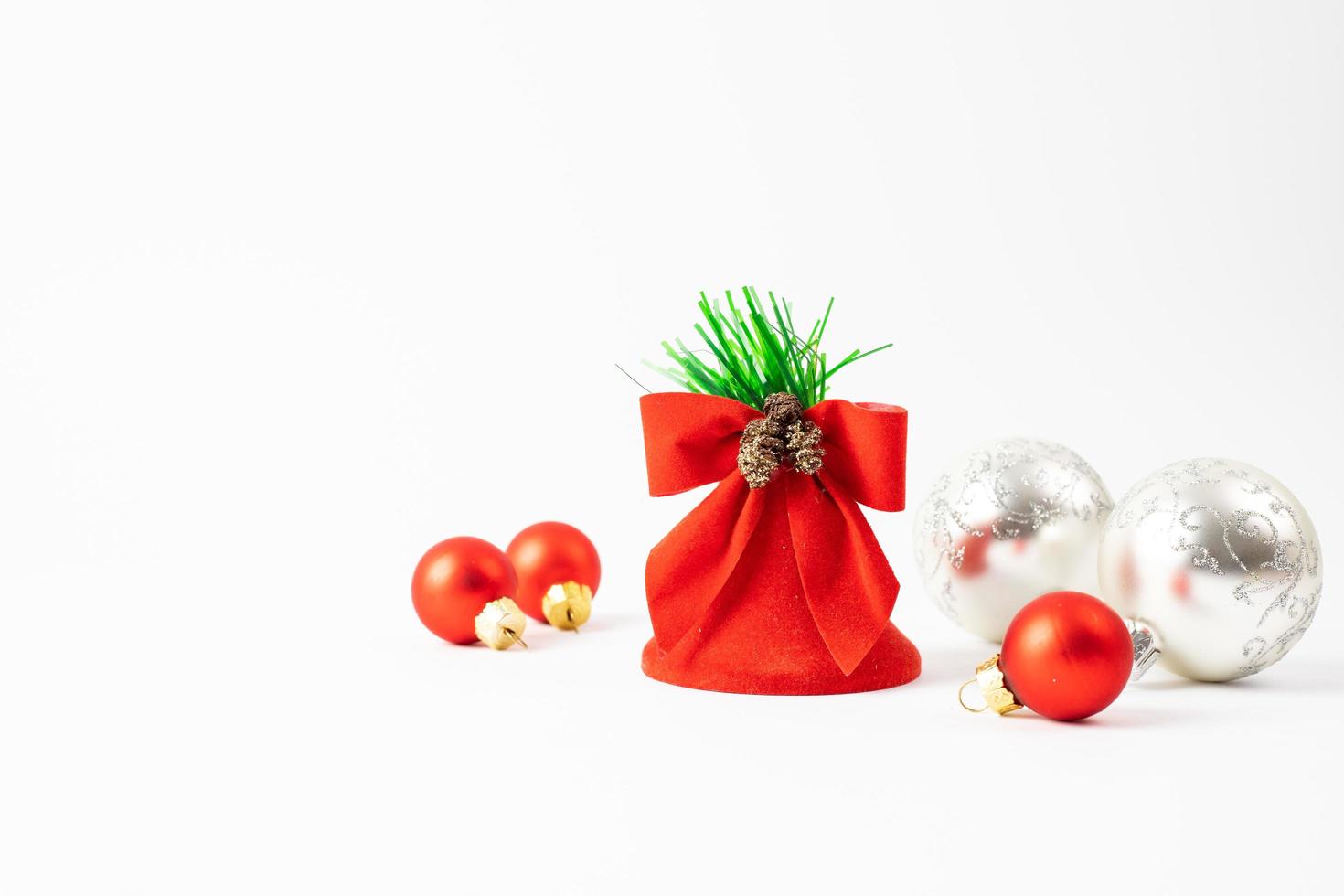 Christmas decoration on a white background. Red Christmas tree balls and a bell. Place for text. photo