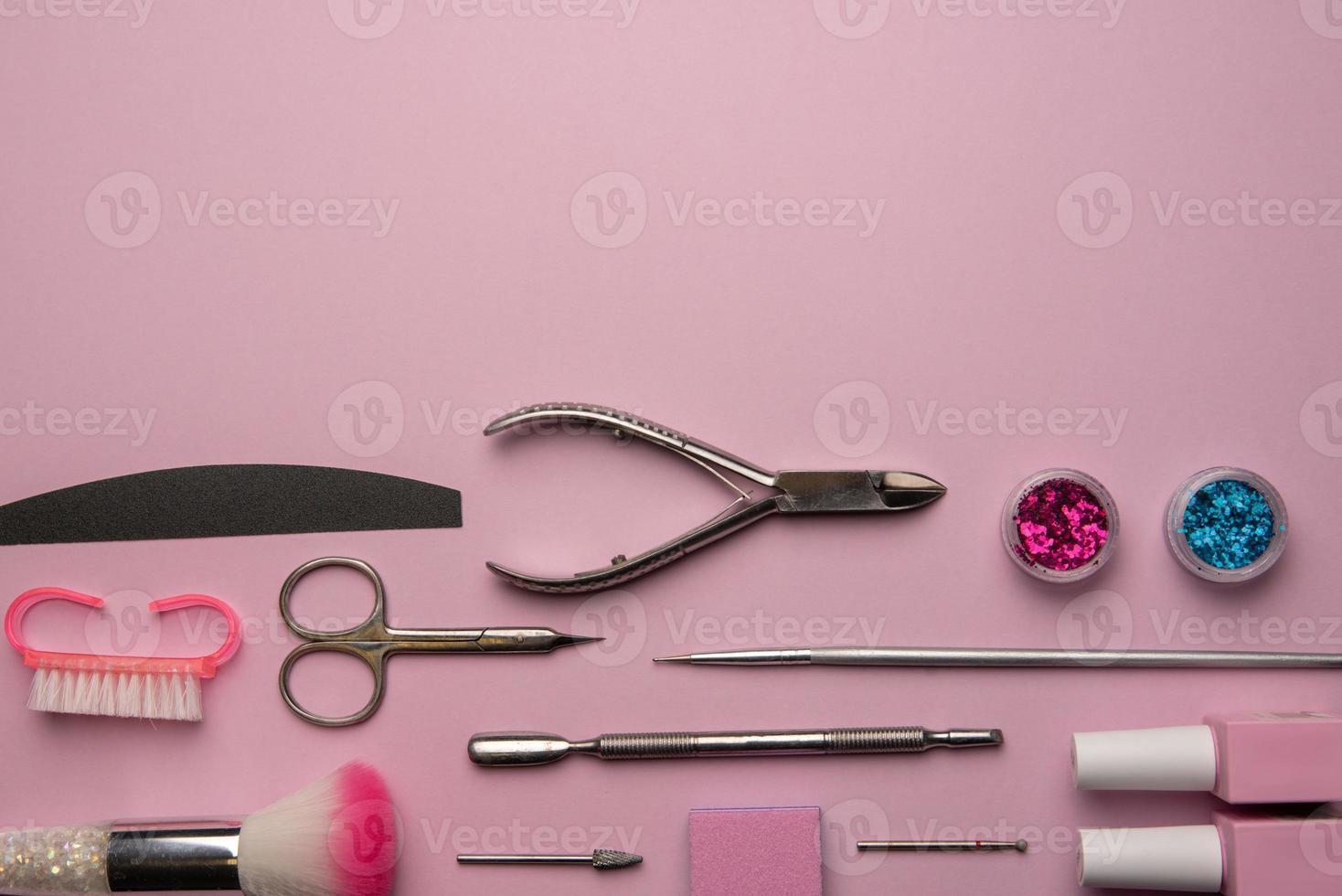 Set of manicure tools and accessories on a pink background. Hardware manicure,Flat lay. photo