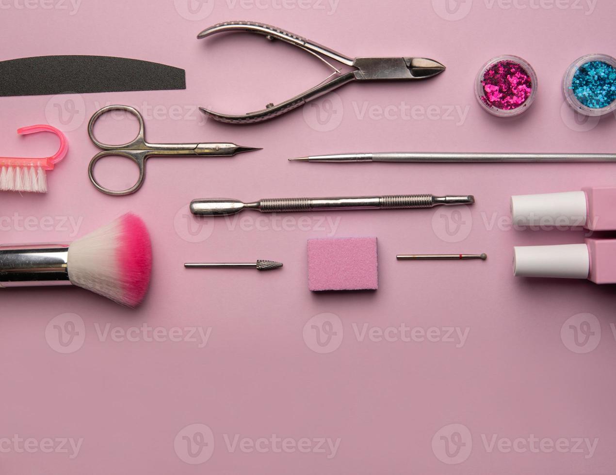 Set of manicure tools and accessories on a pink background. Hardware manicure,Flat lay. photo