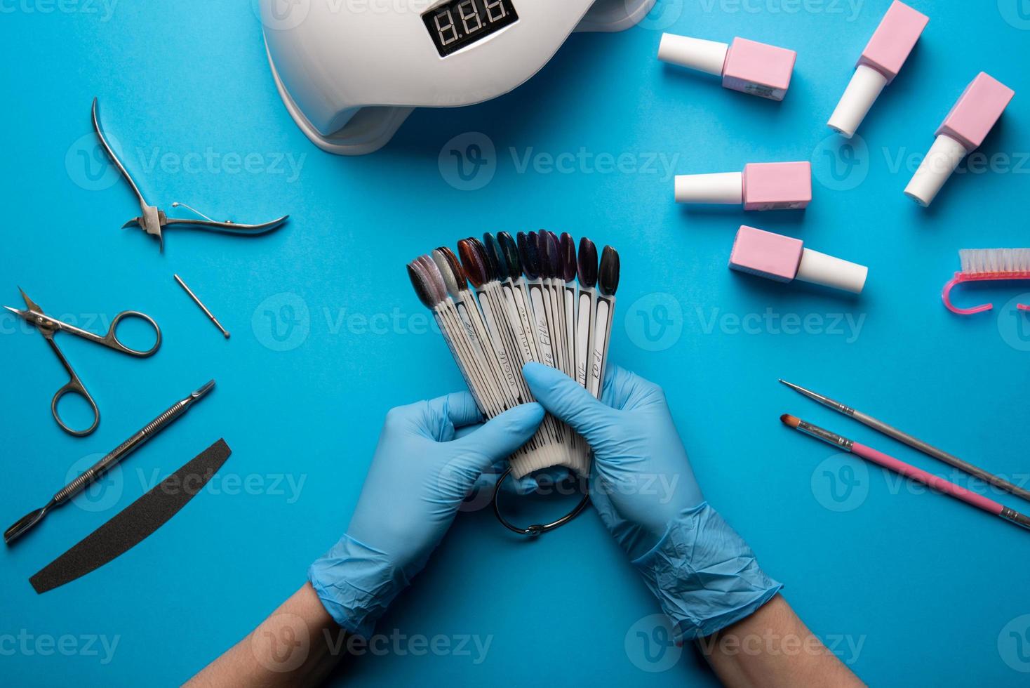 conjunto de herramientas y accesorios de manicura sobre un fondo azul. manicura de hardware, endecha plana. foto
