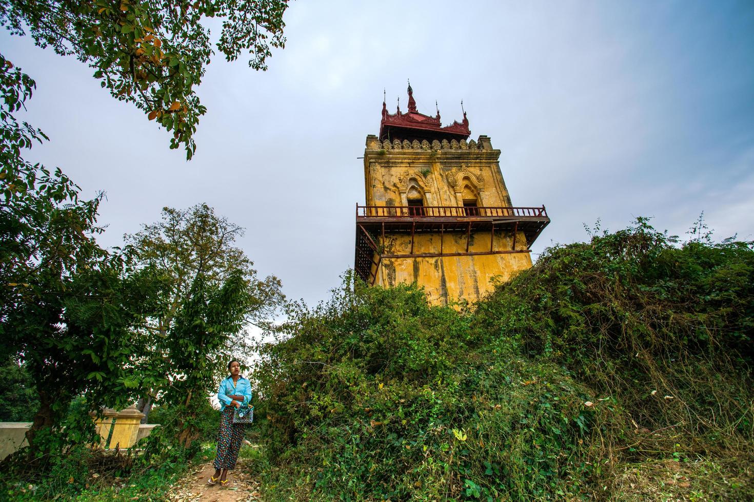 mandalay, myanmar - 7 de enero de 2019 - mujer local caminando hacia los turistas para ofrecer los productos hechos a mano en la torre de vigilancia de nanmyin, o torre inclinada de inwa foto