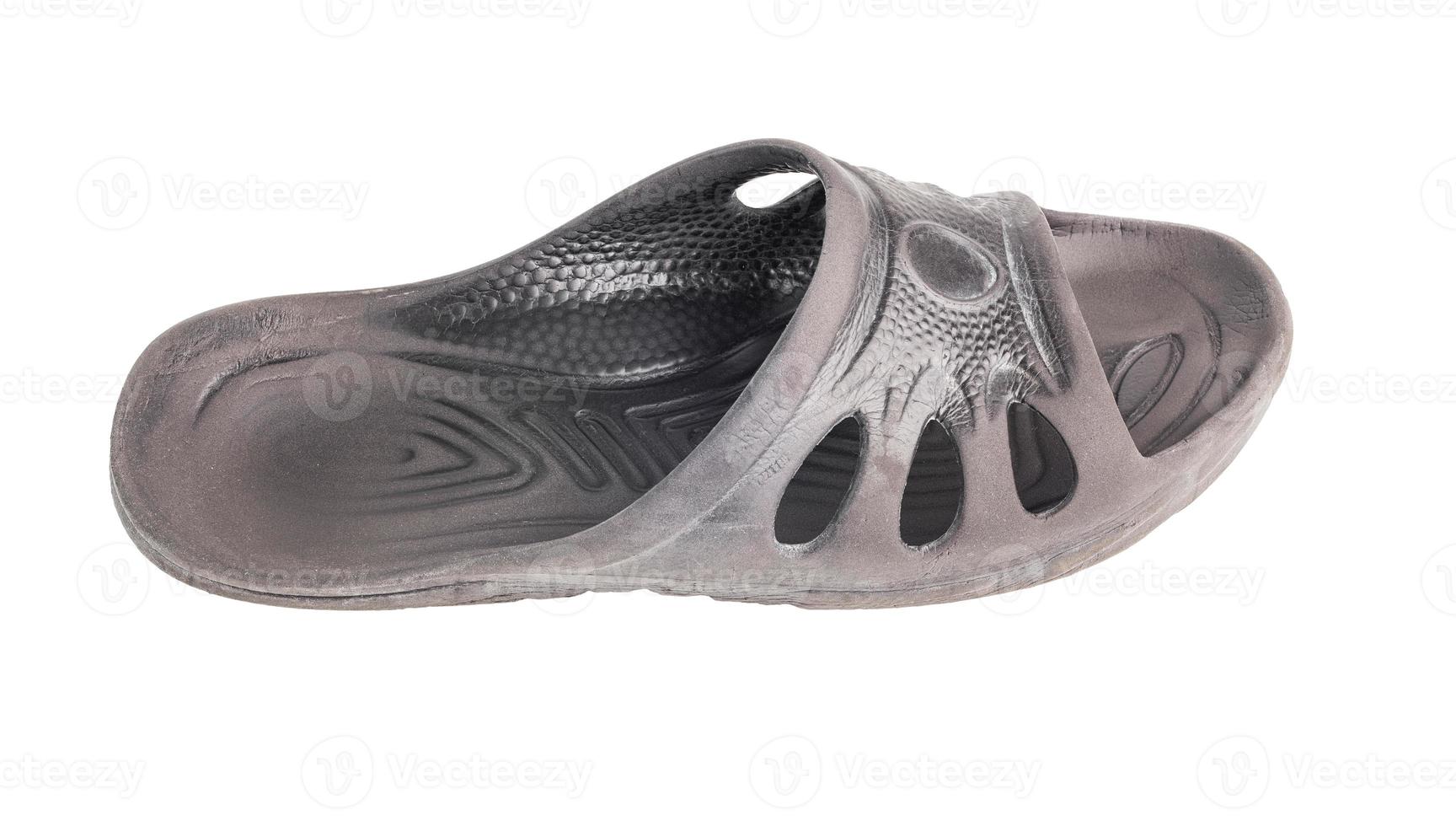 one used cheap black soft rubber slipper with signs of friction wear isolated on white background photo