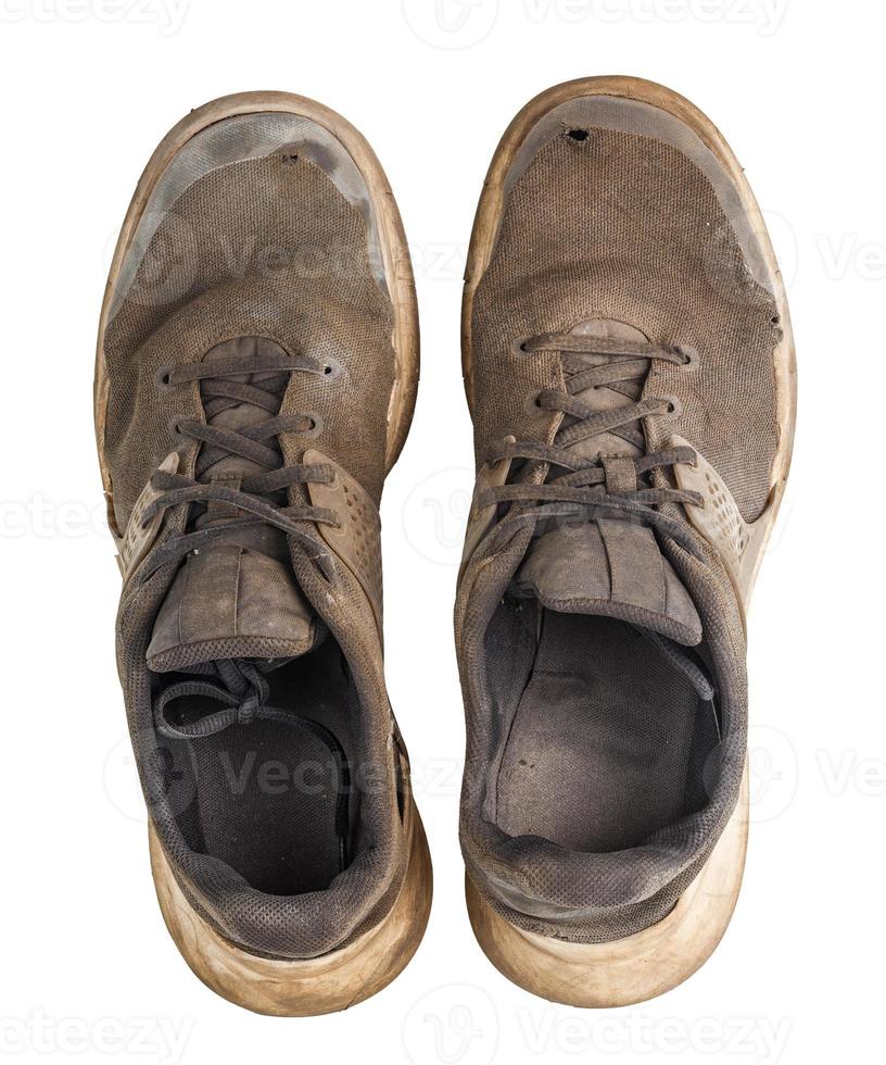 a pair of weared dirty sneakers isolated on white background, flat lay vew from above photo