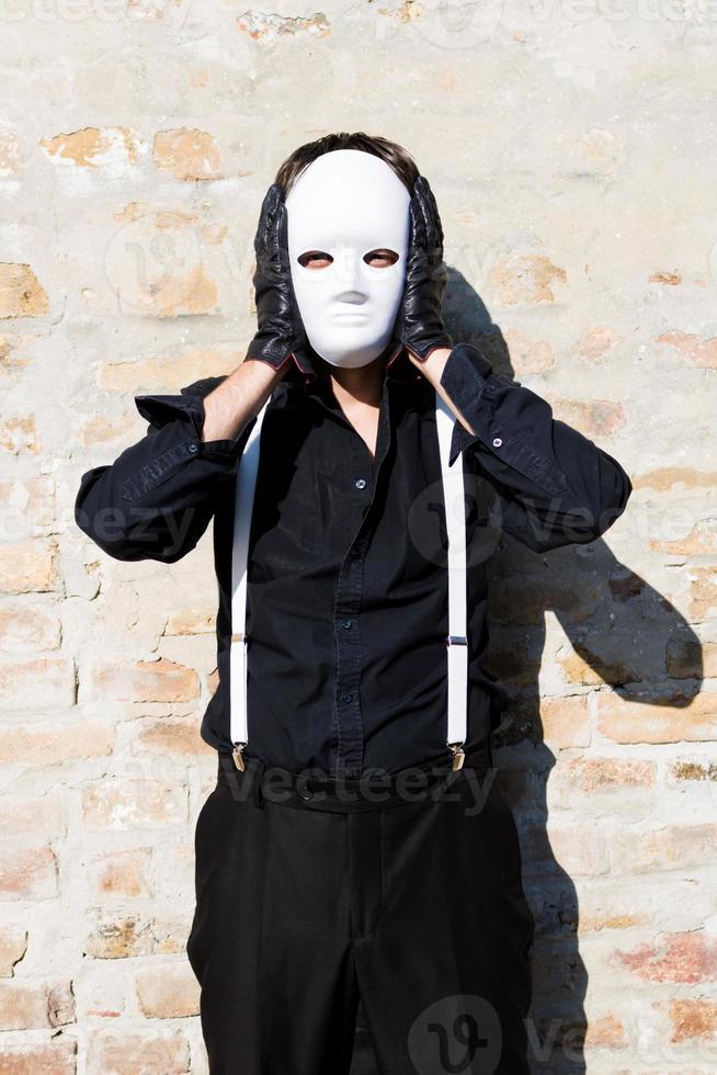 Dependencia Realmente Intenso hombre anónimo con máscara blanca contra la pared. 12663393 Foto de stock  en Vecteezy