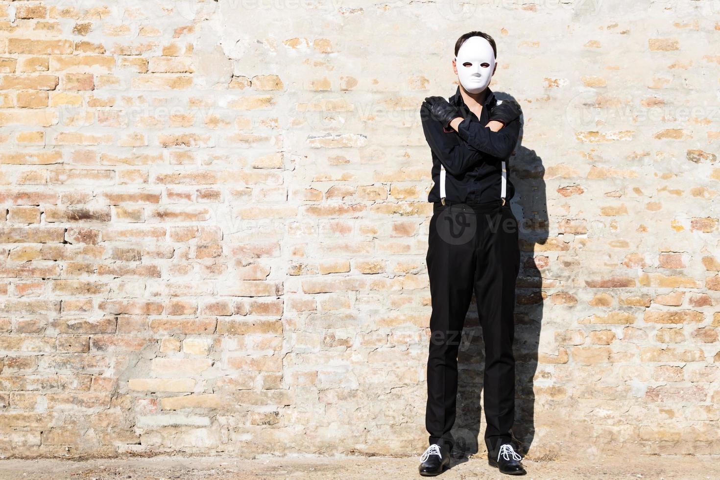 Full length of a man with mask against the wall. photo