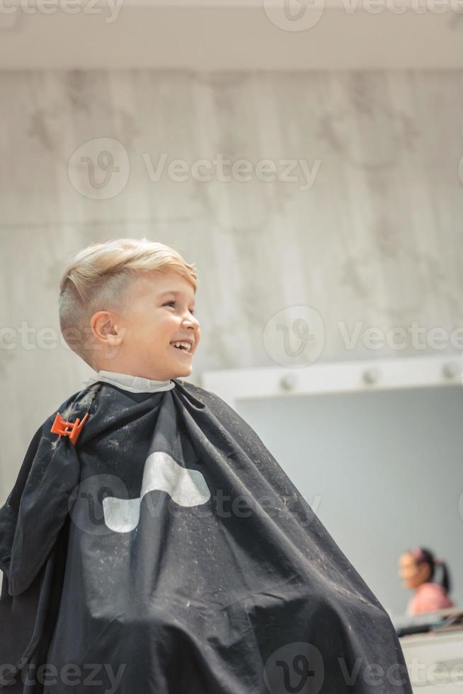 Happy kid at barber shop. photo