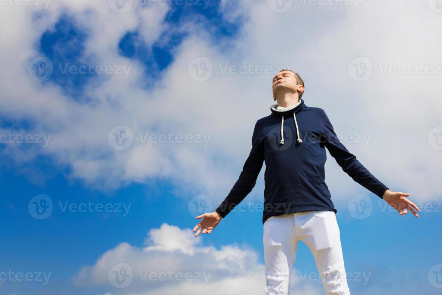 Carefree man with eyes closed enjoying in freedom against the sky. photo