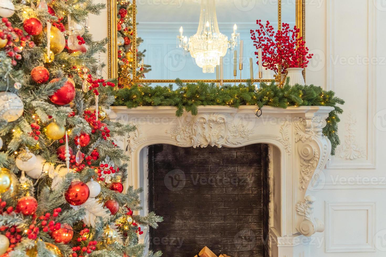 Classic Christmas decorated interior room, New year tree with red and gold decorations. Modern white classical style interior design apartment with fireplace and Christmas tree. Christmas eve at home. photo