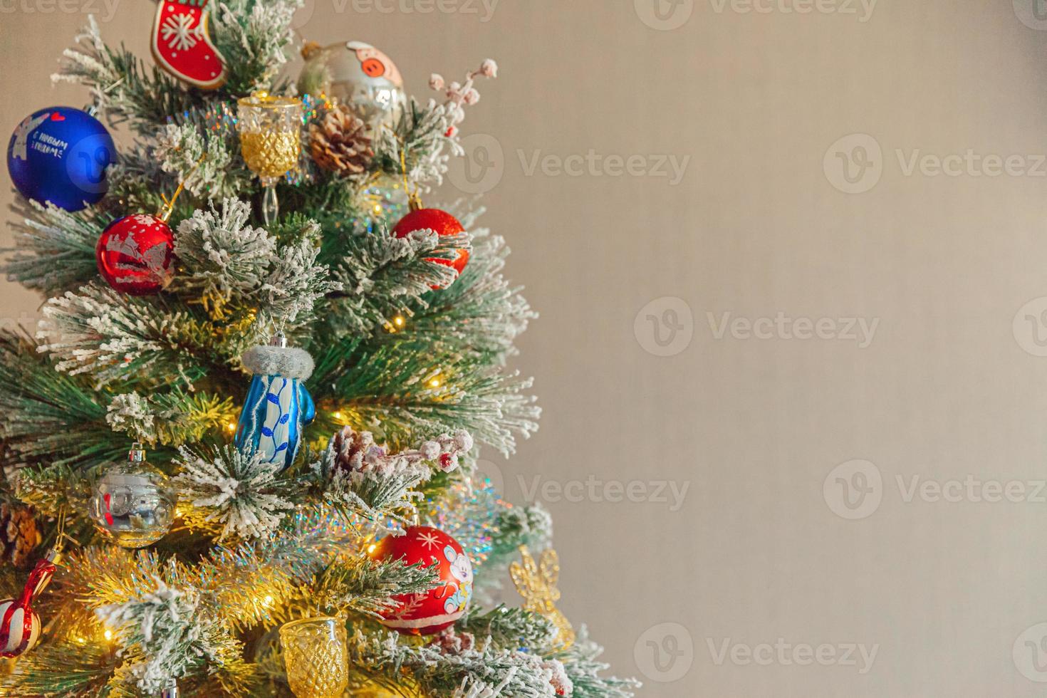 Classic Christmas decorated New year tree with red blue and white ornament toy and ball on gray wall background. Modern classical style interior design apartment. Christmas eve at home. Copy space. photo