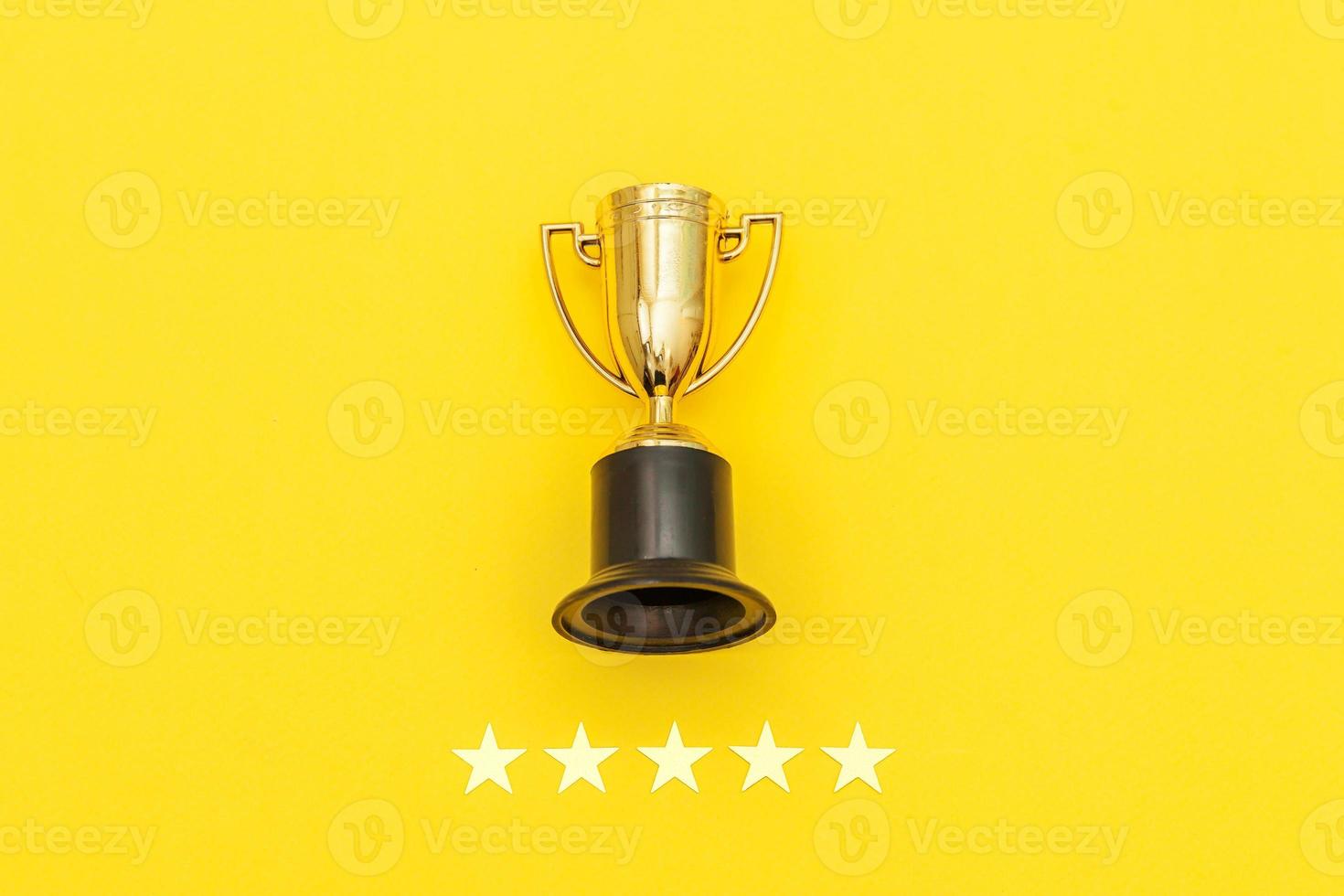 Simply flat lay design winner or champion gold trophy cup and 5 stars rating isolated on pink pastel background. Victory first place of competition. Winning or success concept. Top view copy space. photo