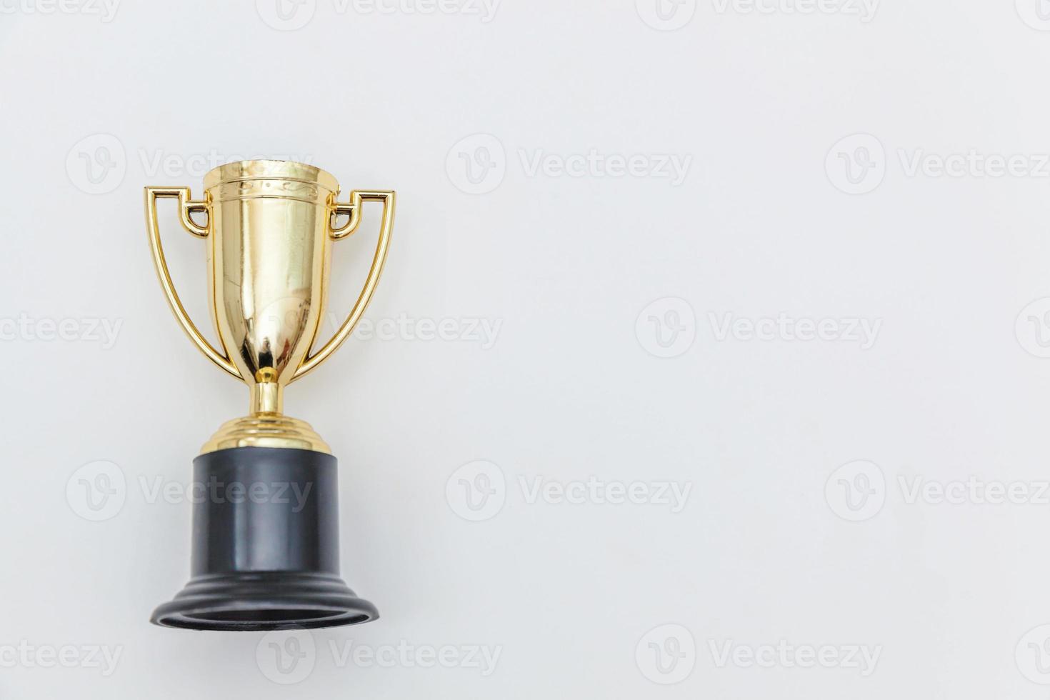 Simply flat lay design winner or champion gold trophy cup isolated on white background. Victory first place of competition. Winning or success concept. Top view copy space. photo