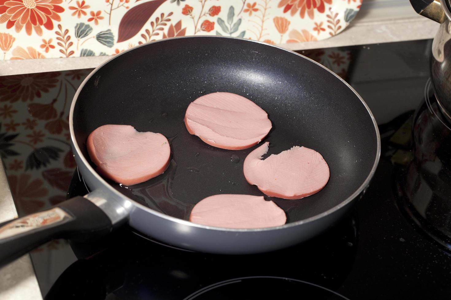 pieces of sausage fried in a pan 12664012 Stock Photo at Vecteezy
