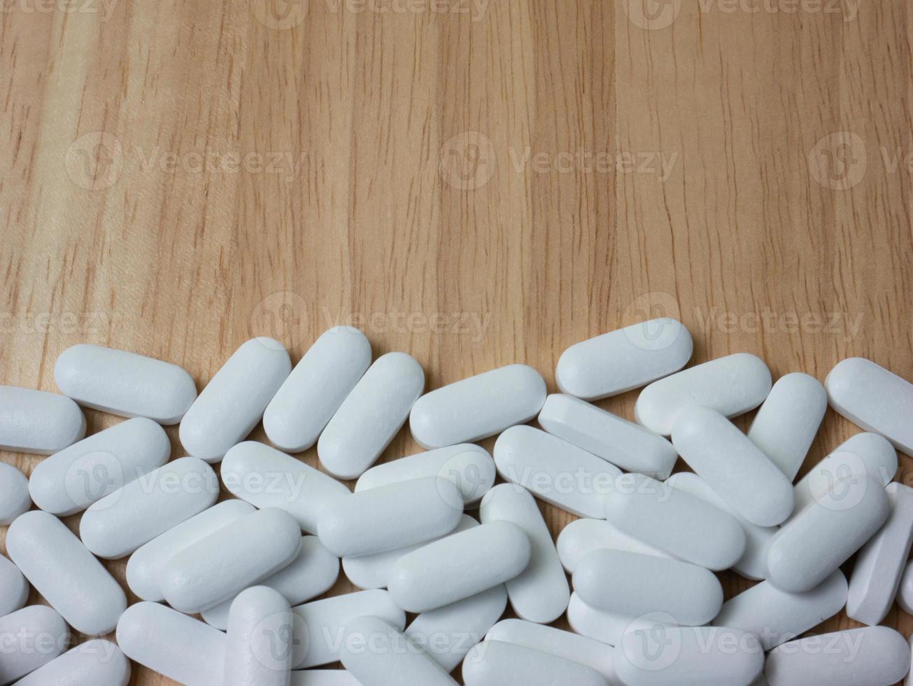 white pill on wood table for sci or medical concept photo